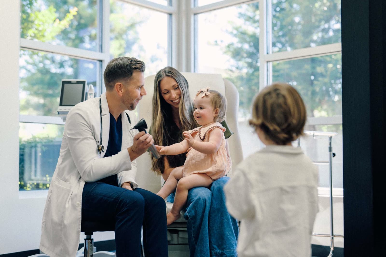 A Smith Family Medicine doctor with a mother and her two young children